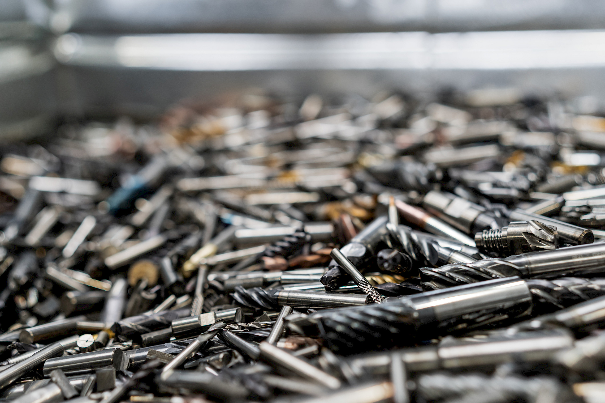 Ein Haufen von verschiedenen Hartmetall-Bohrern und Schneidwerkzeugen in einem Container.