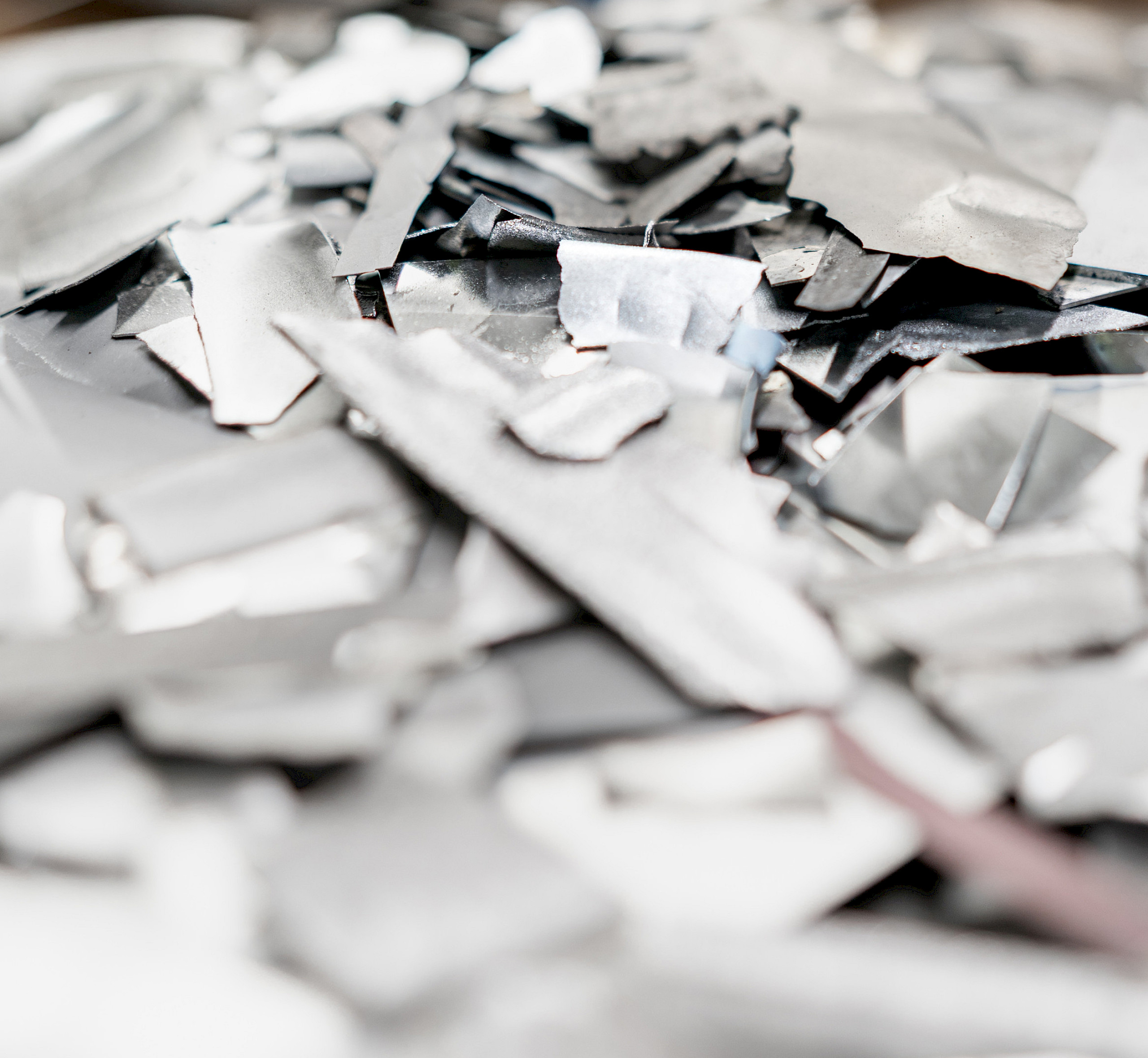 Haufen von Titanlegierungsfragmenten in verschiedenen Formen und Größen auf einer Oberfläche.